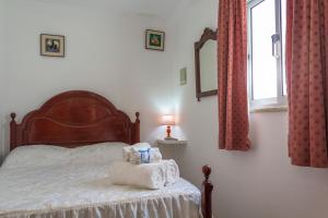 a bedroom with a bed with towels on it at Casas da Bela - Bairro Típico na Nazaré in Nazaré