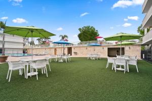 een patio met tafels, stoelen en parasols bij Park Royal Orlando in Kissimmee