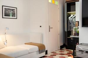a bedroom with a white bed and white walls at Magnolia Boutique Rooms in Catania