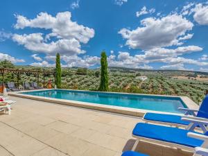 a swimming pool with chairs and a view of the hills at Attractive Villa in Montefrio with Private Pool in Montefrío