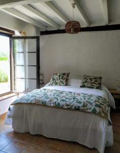 a bedroom with a bed with a white comforter and a window at La résiniere de pirique in Parentis-en-Born