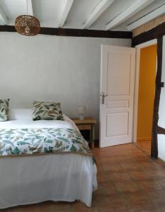 パランティ・アン・ボルヌにあるLa résiniere de piriqueのベッドルーム1室(ベッド1台付)と部屋のドア1室が備わります。