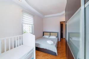 a small bedroom with two beds and a sink at Уютная квартира у моря in Batumi