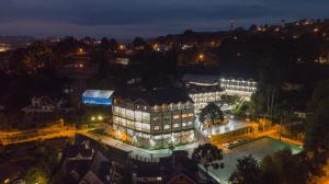 un gran edificio con una piscina frente a él por la noche en Hotel Leão da Montanha, en Campos do Jordão