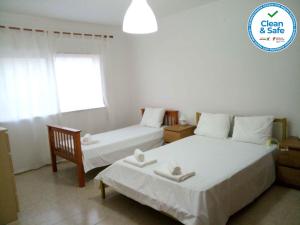 a bedroom with two beds and a sign that says clean and safe at Sol e Praia - Peniche II in Peniche
