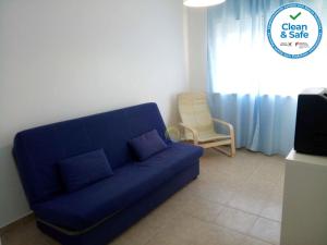 un sofá azul en una sala de estar con una silla en Sol e Praia - Peniche II, en Peniche
