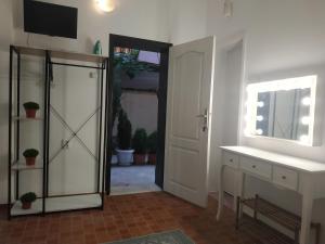 een badkamer met een deur, een wastafel en een spiegel bij Rali Apartments in Kiten