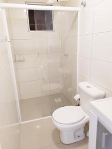 ein weißes Badezimmer mit Toilette und Dusche in der Unterkunft Lindo apartamento Avenida Brasil in Balneário Camboriú