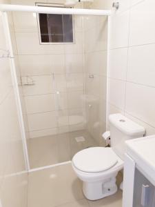 y baño blanco con aseo y ducha. en Lindo apartamento Avenida Brasil, en Balneário Camboriú