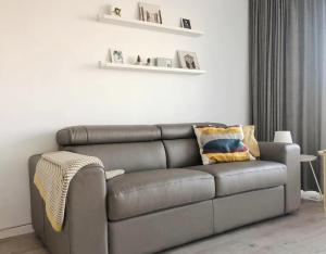 a grey couch in a living room with shelves at Studio Ostend Living in Ostend