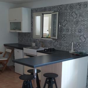 una cocina con encimera y taburetes. en Portocervo House, en Arzachena