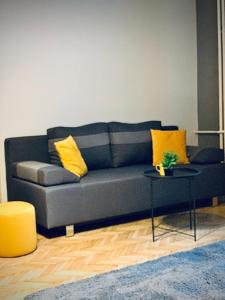 a blue couch with yellow pillows in a living room at Hostel Sova in Novi Sad