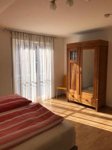 a bedroom with a wooden cabinet and a mirror at Apartment Carmen in Rust