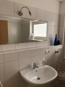 a white bathroom with a sink and a mirror at Apartment Carmen in Rust