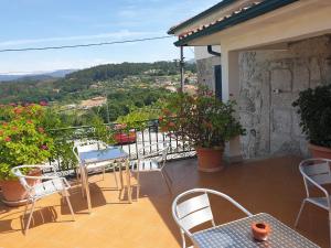 a balcony with tables and chairs and a view at hostel do Ermal in Vieira do Minho
