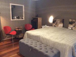 um quarto com uma cama e 2 cadeiras vermelhas em B&B Johannahoeve Veluwe em Hall