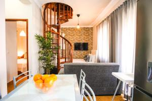 een woonkamer met een tafel en een wenteltrap bij Sol e Mar in Nazaré