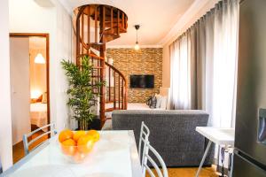 a living room with a table and a spiral staircase at Sol e Mar in Nazaré