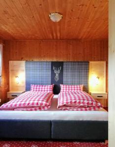 Schlafzimmer mit einem Bett mit roten und weißen Kissen in der Unterkunft Turner-Hütte in Heiligenblut