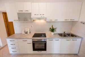 a kitchen with white cabinets and a sink at Landhaus am Berg in Rab +105 photos