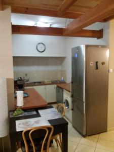 a kitchen with a stainless steel refrigerator and a table at Apartament Makowo in Makowo