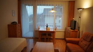 - un salon avec une table, un canapé et un lit dans l'établissement Haus Green 31, à Davos