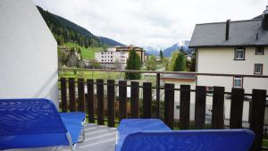 a balcony with blue chairs and a view of mountains at Haus Green 31 in Davos