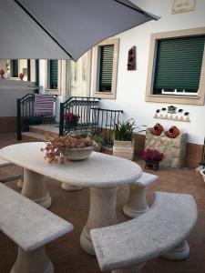 - une table et des chaises avec un parasol sur la terrasse dans l'établissement Moradia Valdemar, à Nazaré