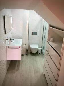 La salle de bains est pourvue d'un lavabo blanc et de toilettes. dans l'établissement Moradia Valdemar, à Nazaré