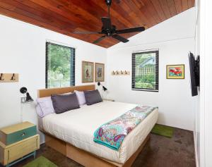 um quarto com uma cama e uma ventoinha de tecto em Folly Vacation 202 Beach Bungalow em Folly Beach