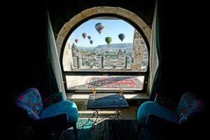 a room with two chairs and a window with hot air balloons at Arinna Cappadocia in Goreme