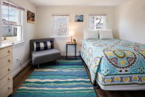 1 dormitorio con 1 cama, 1 silla y ventanas en Truro Beach Cottages, en Truro