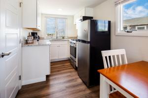 a kitchen with a black refrigerator and a table at Truro Beach Cottages in Truro
