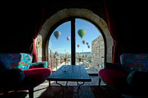 a room with a table and hot air balloons in the sky at Arinna Cappadocia in Goreme