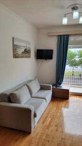 ein Wohnzimmer mit einem Sofa und einem TV in der Unterkunft Nafpaktos Beach House in Nafpaktos
