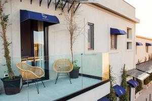 a patio area with chairs, tables and umbrellas at Magnolia Boutique Rooms in Catania