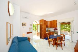 a living room with a blue couch and a table at Appartamenti Villa Maria in Ischia