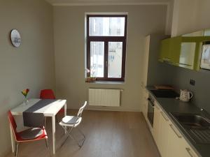 uma cozinha com mesa e cadeiras e uma janela em KaVi apartments #2 em Plzeň