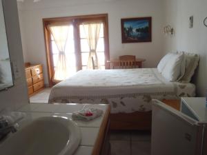 a bathroom with a bed and a sink and a tub at Corona del Mar in San Pedro