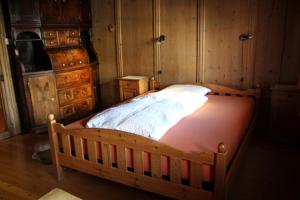 a large bed in a bedroom with wooden walls at Chasa Marugg - Ferienwohnung für 4-5 Personen, 70m2 in Scuol