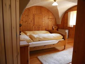 um quarto com uma cama num quarto de madeira em Chasa Marugg - Ferienwohnung für 4-5 Personen, 70m2 em Scuol