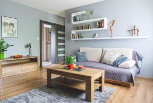 a living room with a couch and a coffee table at Przestronny Apartament in Grzybowo