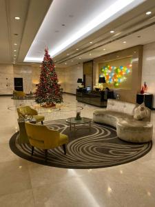 a christmas tree in a lobby with a couch and chairs at Venice Luxury Studio w/Balcony @McKinley Hill in Manila