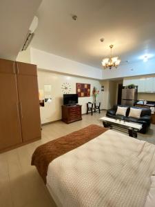 a bedroom with a large bed and a living room at Venice Luxury Studio w/Balcony @McKinley Hill in Manila