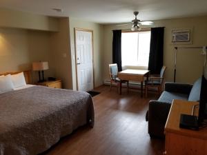 a hotel room with a bed and a table and chairs at Osoyoos Lakeview Inn & Suites in Osoyoos