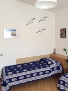 a bedroom with a bed with birds on the wall at La Residenza in Porto Azzurro
