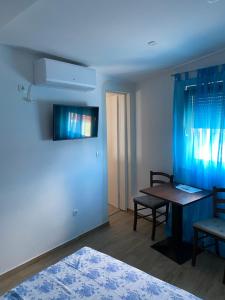 a room with a table and a blue wall at Apartmani Bella Vista in Njivice