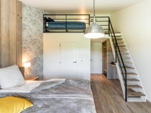 a loft bedroom with a bed and a staircase at Bed en Vrijheid in Peer