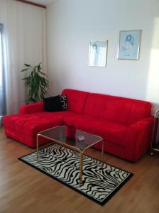 a red couch in a living room with a coffee table at Apartmani Antunović Podgora in Podgora