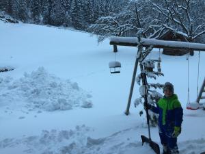 a boy standing on a ski lift in the snow at Alpenapart Walch in Jerzens